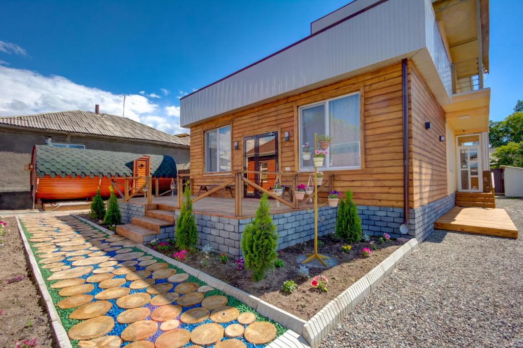 a wooden house with a pathway in front of it at Hillside Karakol B&B in Karakol