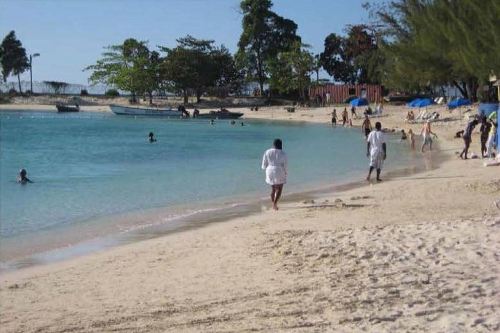 un gruppo di persone che camminano su una spiaggia di MoBay Las Palmas a Montego Bay