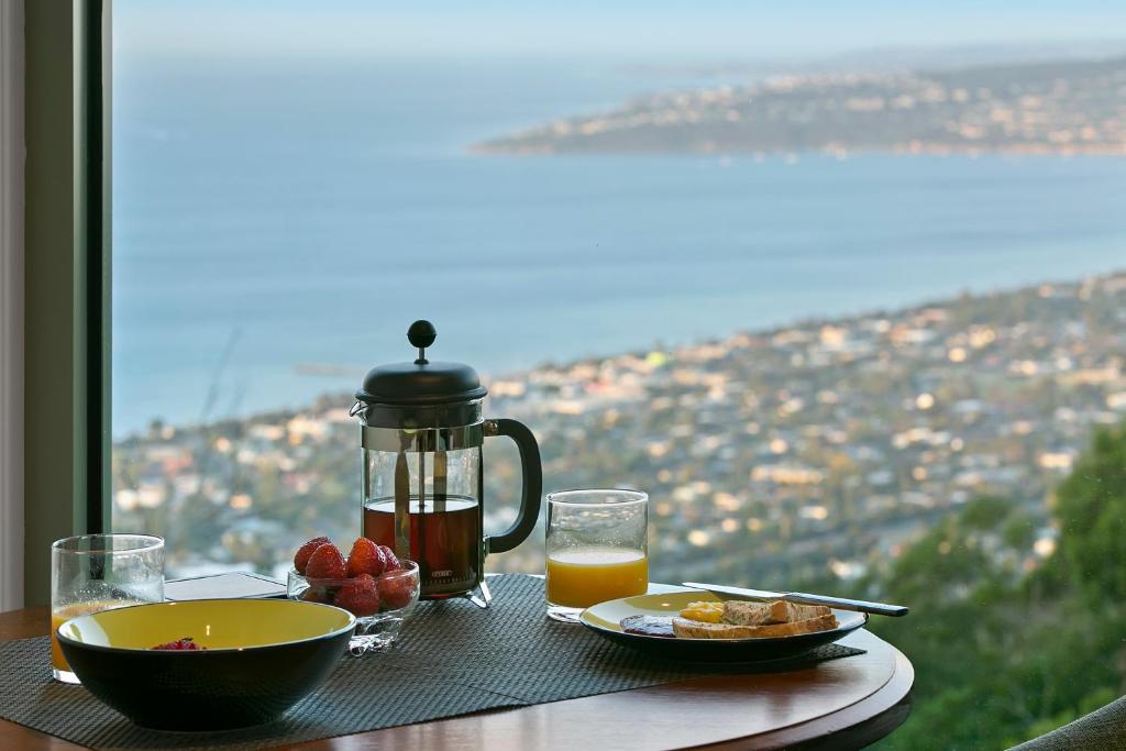 una mesa con un plato de comida y una jarra de zumo de naranja en Arthurs Views, en Arthurs Seat