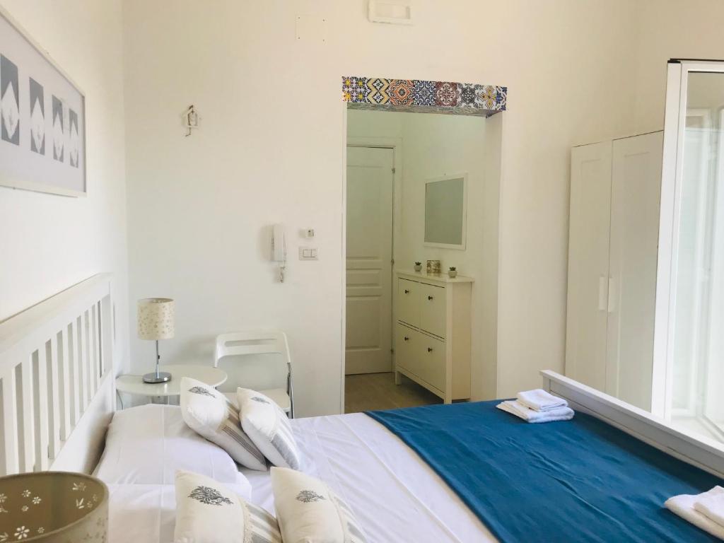 GiuggianelloにあるLe Fiche d’Indiaの白いベッドルーム(ベッド1台、椅子付)
