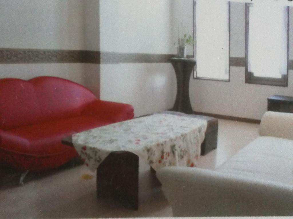 Takizawa的住宿－Mizubasho，客厅配有红色椅子和桌子