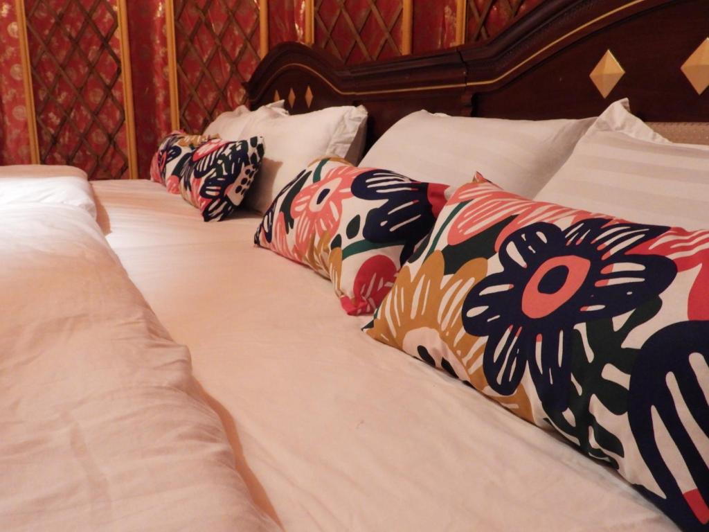 Una cama con sábanas blancas y almohadas. en Matsu E19 en Nangan