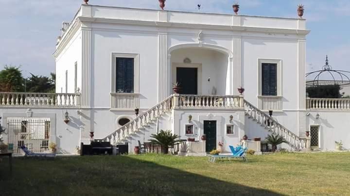 a large white house with a staircase in the yard at Villa Longo de Bellis in Bari
