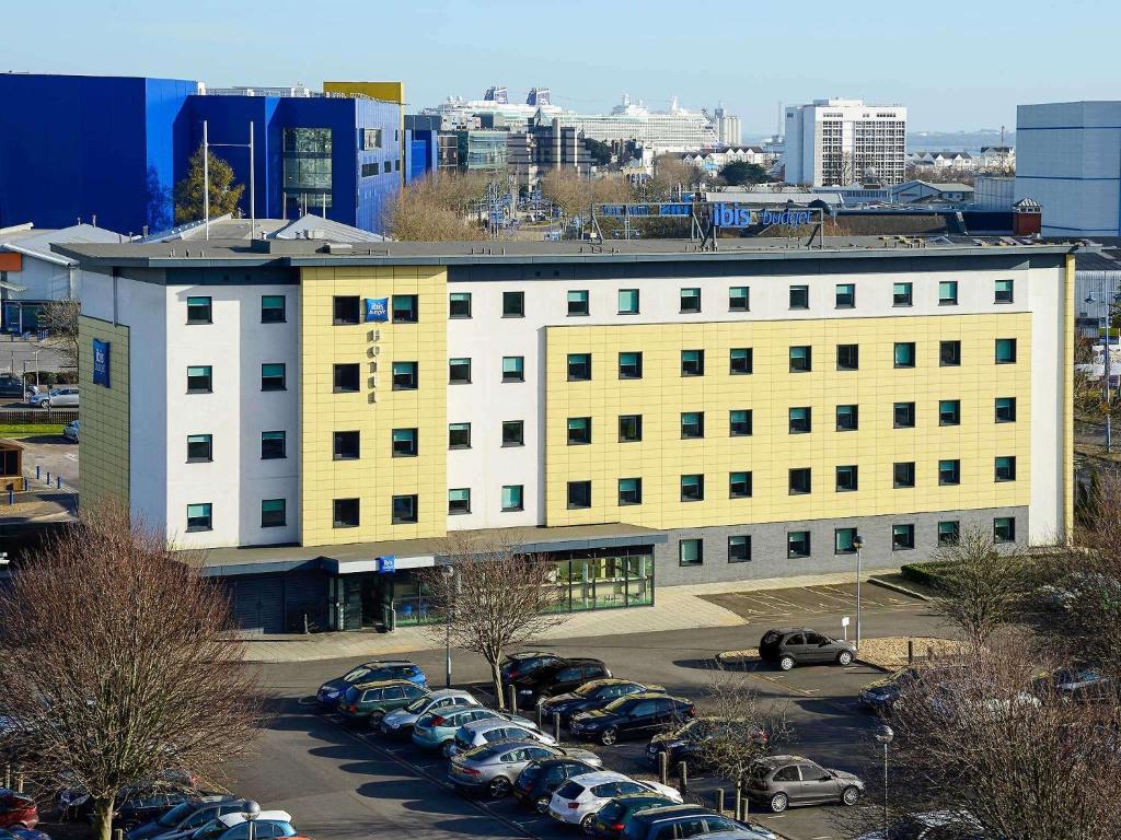 un gran edificio blanco con coches aparcados en un aparcamiento en ibis budget Southampton Centre, en Southampton