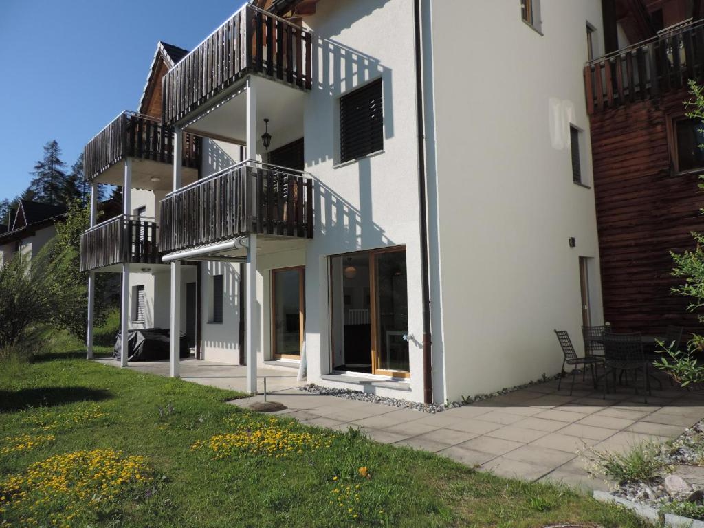 a white building with balconies and a patio at Alpenrose (295 Av) in Brienz-Brinzauls