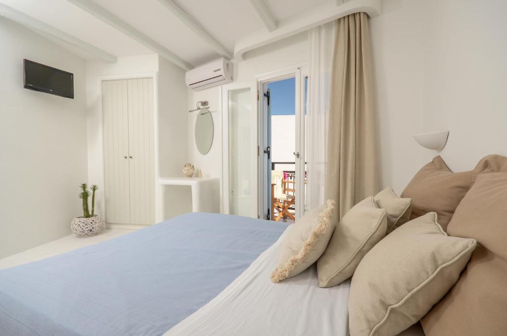 1 dormitorio blanco con 1 cama grande y ventana en Helen Studios, en Naxos Chora