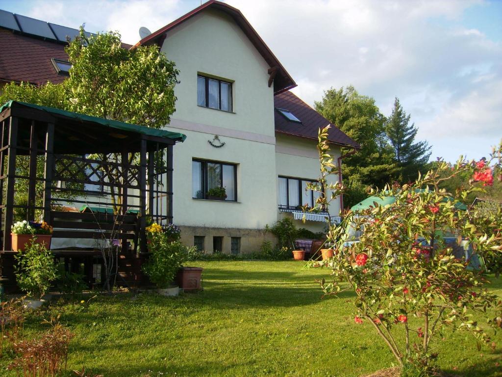 a white house with a yard with a garden sidx sidx at Pension u Josefa in Košťálov