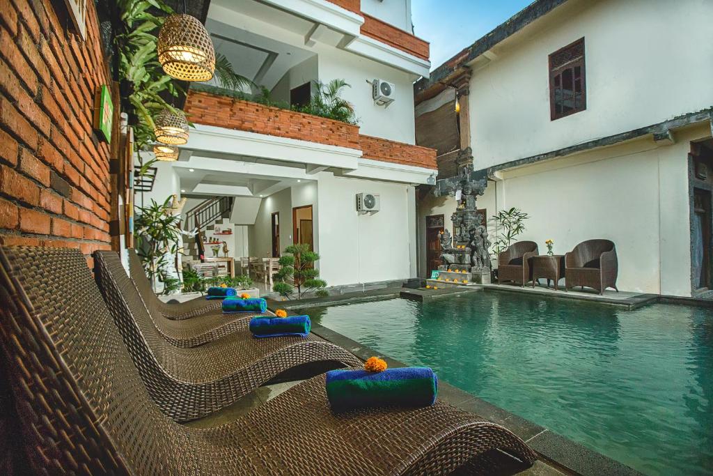 uma piscina num edifício com espreguiçadeiras na água em Ubudku Villas em Ubud