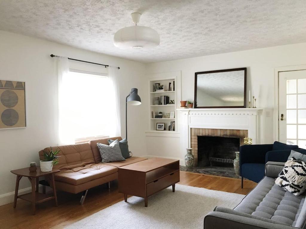 Una sala de estar con un sofá y una chimenea. en 1940's Bungalow near Downtown & UT Campus, en Knoxville