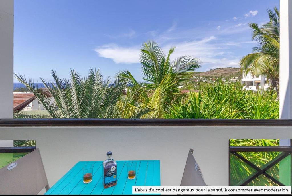 einen Tisch auf dem Balkon mit Blick auf Palmen in der Unterkunft Boucan Beach Joli studio vue mer à Boucan Canot in Boucan Canot
