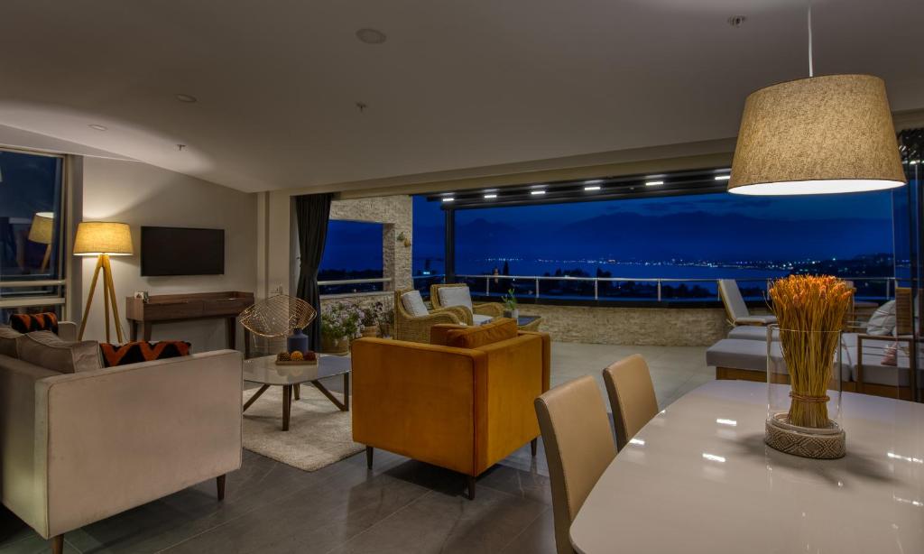 ein Wohnzimmer mit einem Esstisch und ein Wohnzimmer mit Aussicht in der Unterkunft Arkk Homes in Antalya