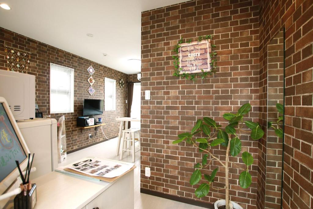 a brick wall in a kitchen with a plant at guesthouse yu -SEVEN Hotels and Resorts- in Yomitan