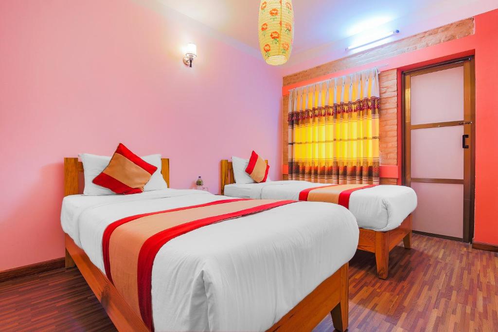 two beds in a room with pink walls at Hotel Everest Window View in Nagarkot