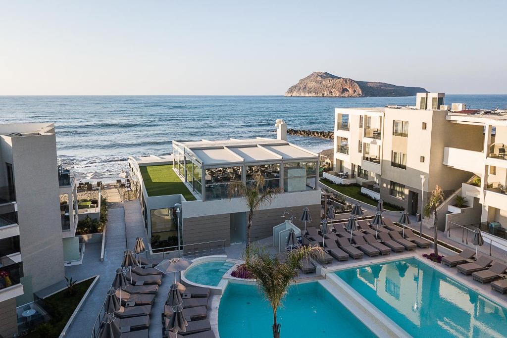 an aerial view of a resort with a swimming pool and the ocean at Porto Platanias Beach Luxury Selection - Adults Only in Plataniás