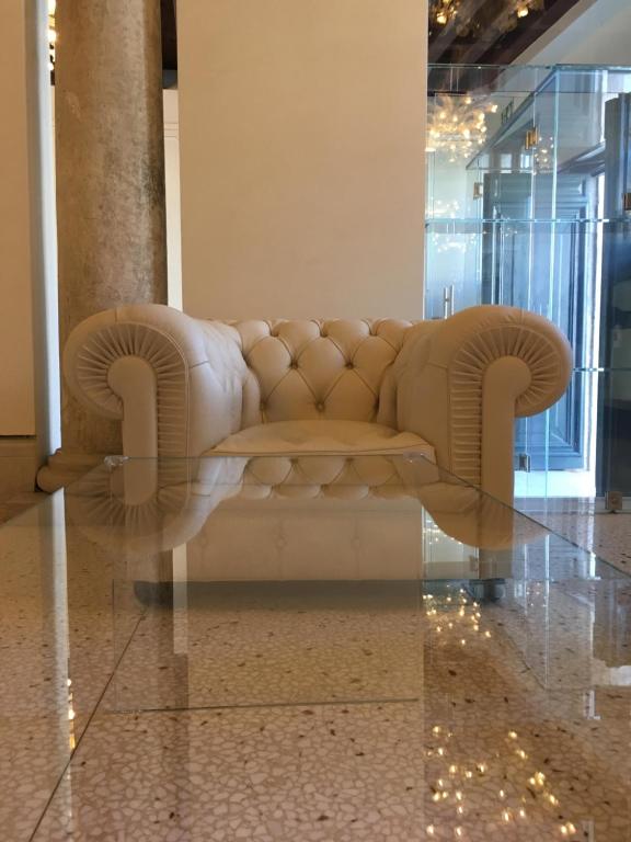 a couch sitting in a lobby with a reflection of it at Ca' Bonfadini Historic Experience in Venice