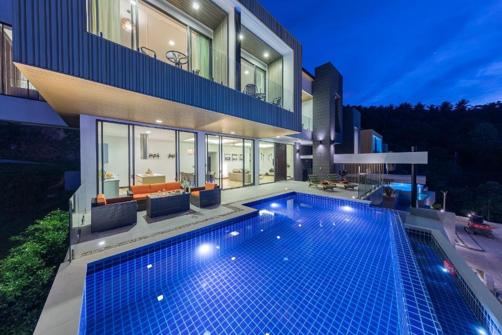 a swimming pool in front of a house at night at Luxury Verano Residence 3 Bedroom Seaview Villa Chaweng Noi in Bophut 