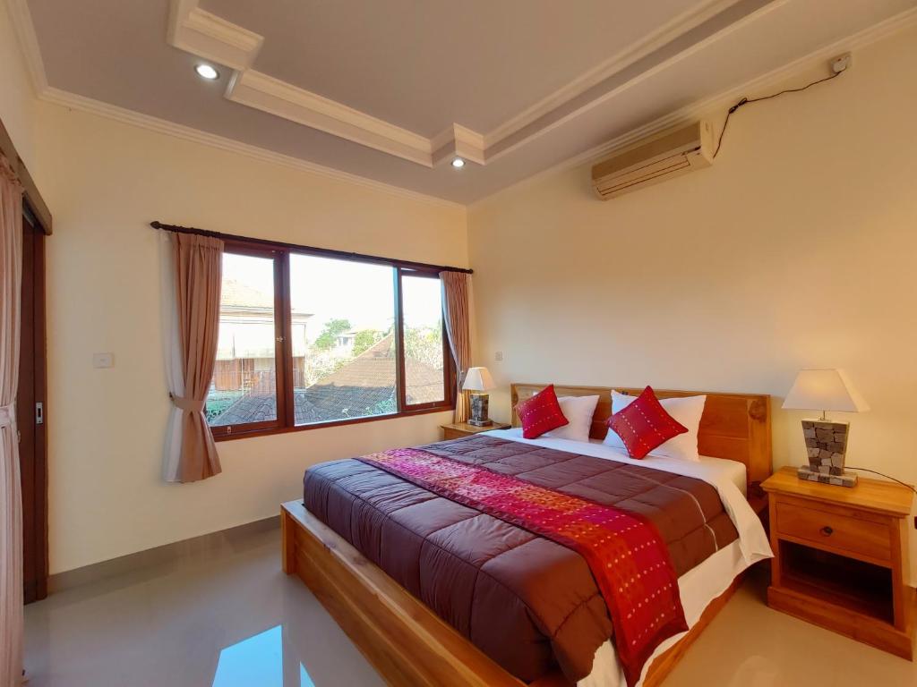 una camera con un letto e una grande finestra di Jero Ratna Homestay ad Ubud