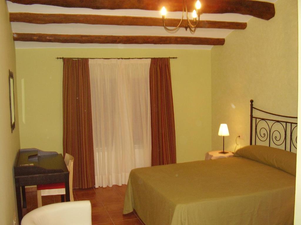 Alborge的住宿－Casa De Los Diezmos，一间卧室配有一张床、一张书桌和一个窗户。