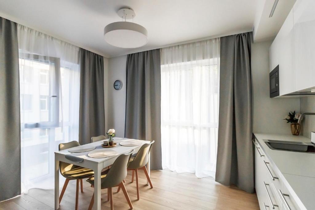 a kitchen and dining room with a table and chairs at Krėvos apartamentai in Kaunas