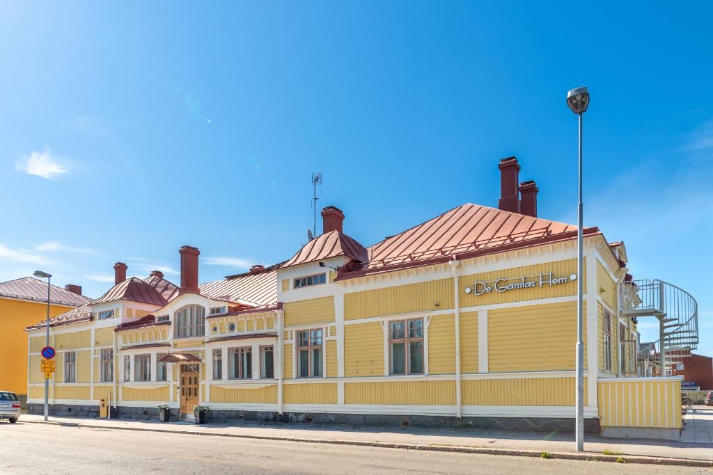 un edificio amarillo al lado de una calle en De Gamlas Hem Hotel & Restaurant en Oulu