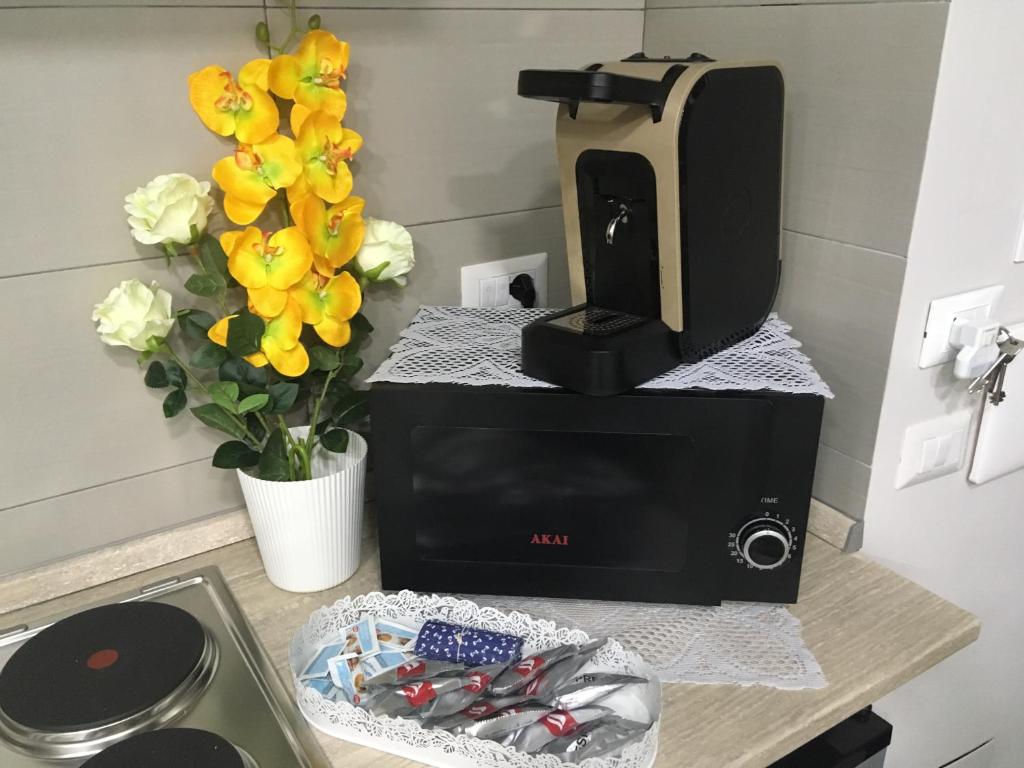ekspres do kawy siedzący na blacie z kwiatami w obiekcie casa piano zero w mieście Neapol