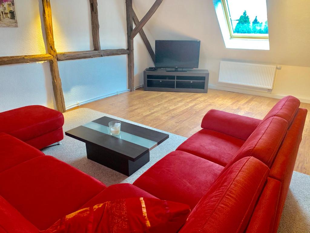 a living room with a red couch and a coffee table at Ferienwohnungen Grimma 3 in Grimma