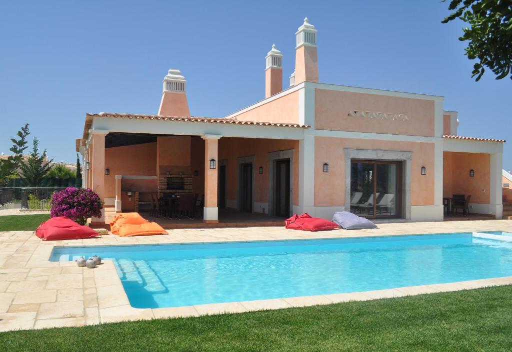 a villa with a swimming pool in front of a house at Cascade Wellness Resort in Lagos