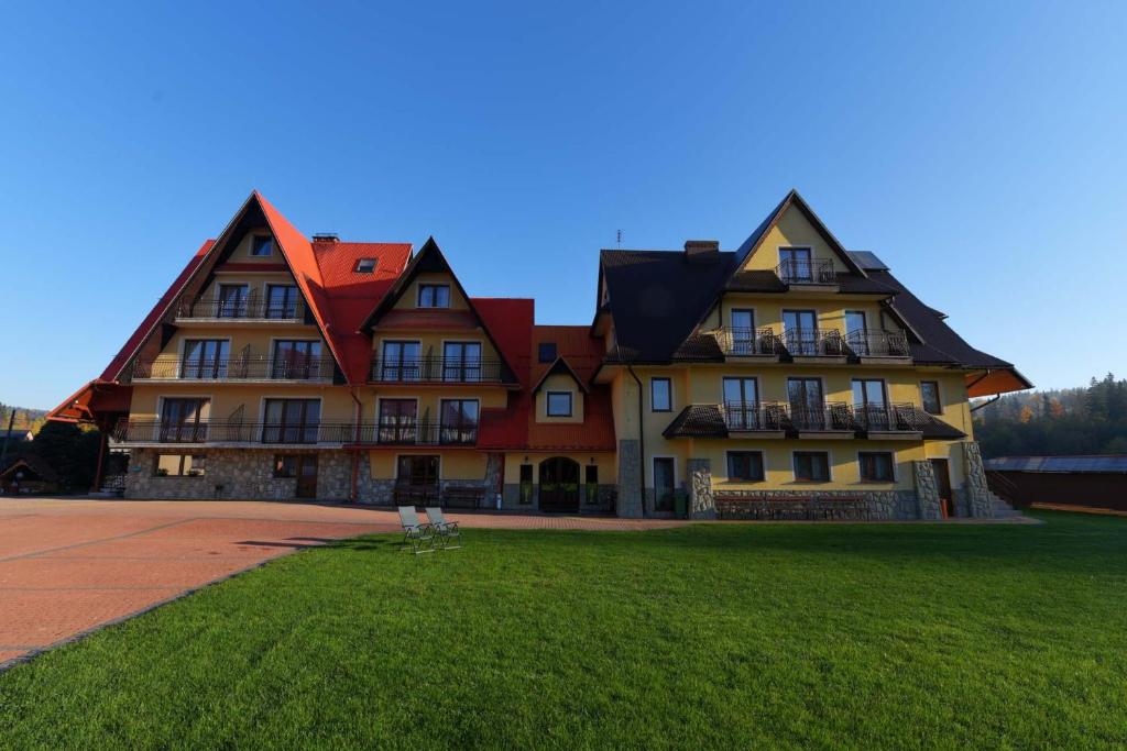 a large house with a green lawn in front of it at Dom Wczasowy Dunajec in Biały Dunajec
