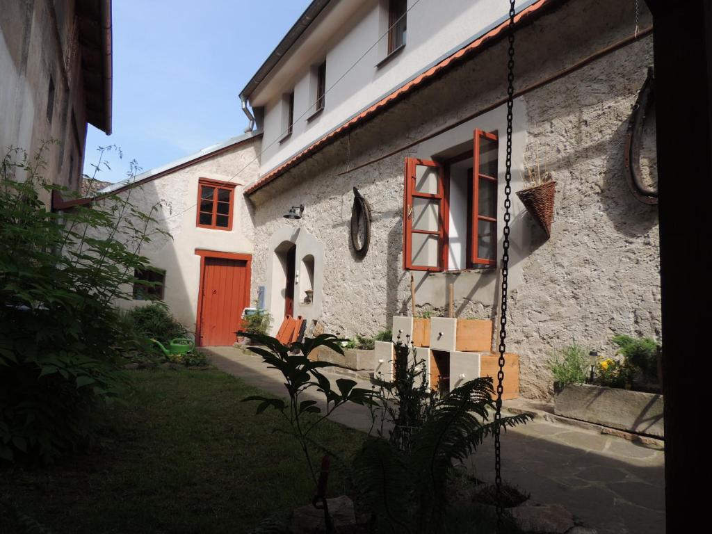 un edificio blanco con una puerta roja y un patio en Apartmán Bechyně, en Bechyně
