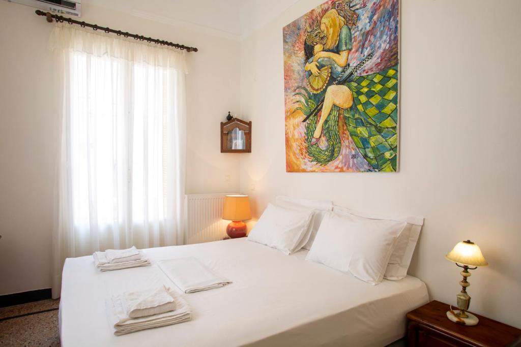 ein Schlafzimmer mit einem weißen Bett und einem Gemälde an der Wand in der Unterkunft Delightful 2 bedr'm 2 bathr'm apt with green roof top! - EP9U in Athen