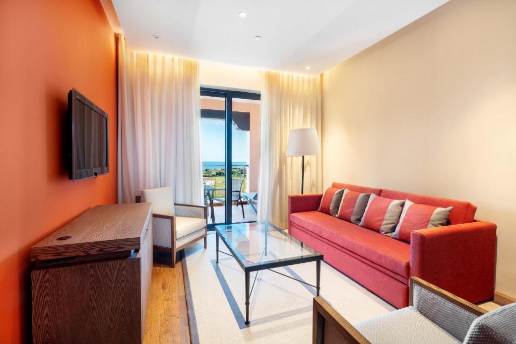 a living room with a red couch and a table at Cascade Wellness Resort in Lagos