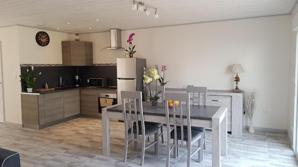 a kitchen and dining room with a table and chairs at La Rose Allass in Grand-Village-Plage