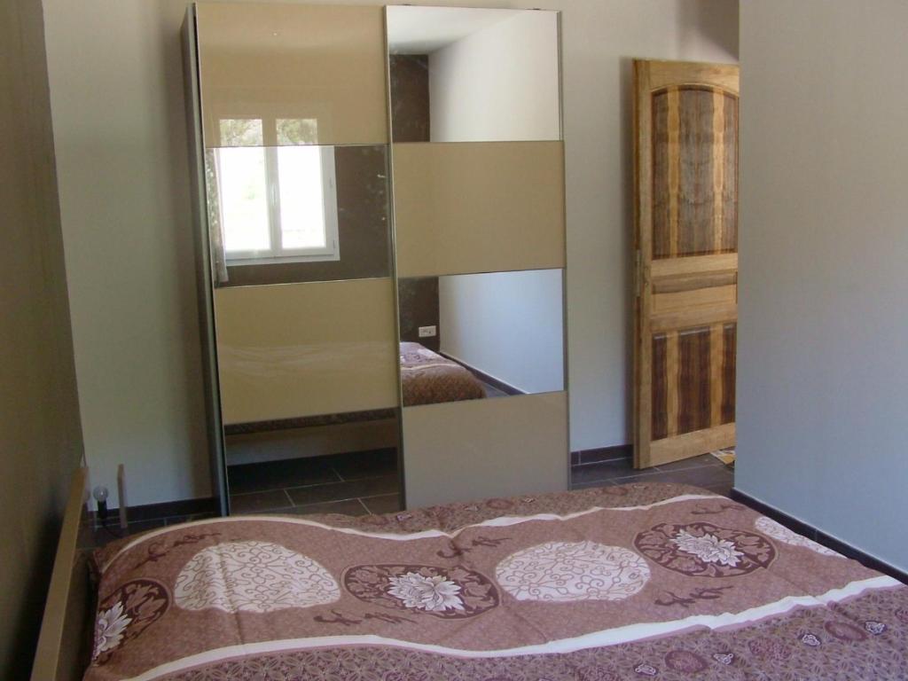 a room with a mirror and a bed in it at B&B Villa Chante Coucou in Fontaine-de-Vaucluse