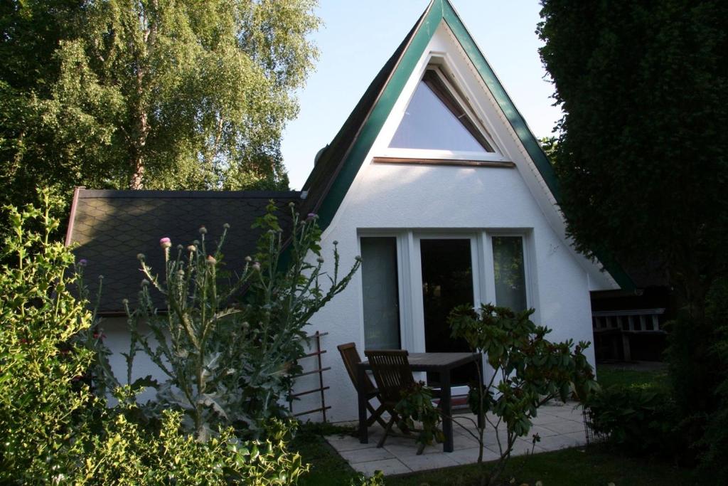 a small white house with a table and chairs at Strandstübchen in Zingst