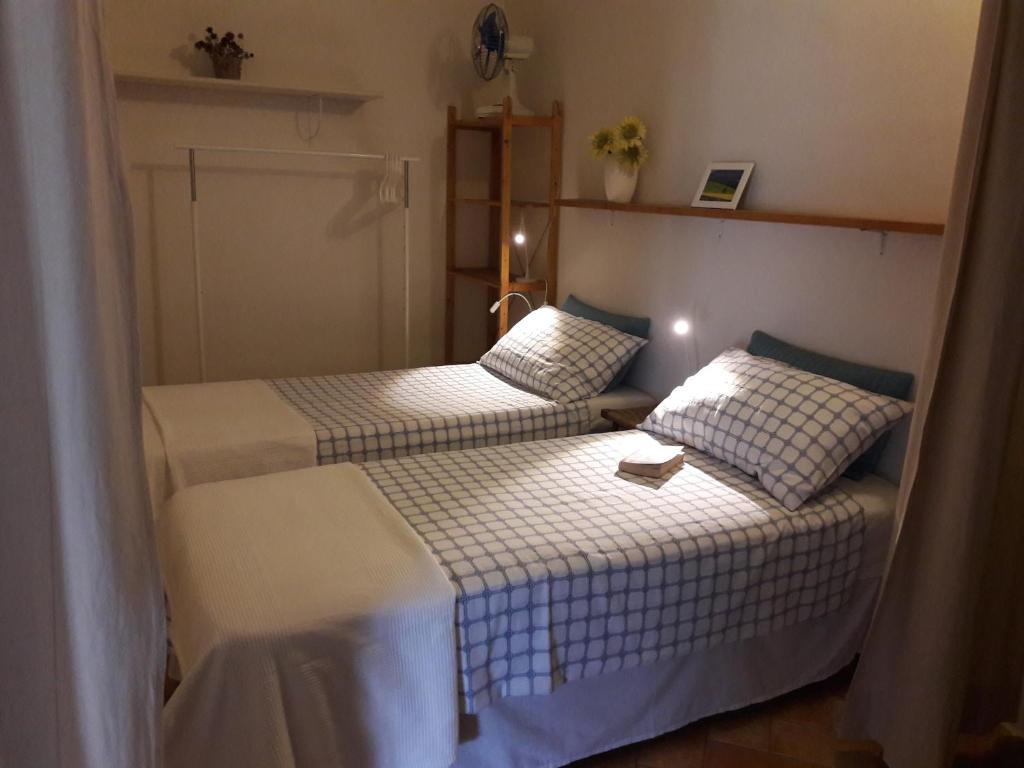 a small room with two beds and a table at Agriturismo Fattoio alle Ripe - Frantoio in SantʼEllero