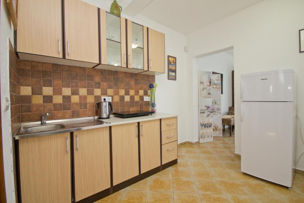a kitchen with a sink and a refrigerator at Apartments Dora in Dobra Voda