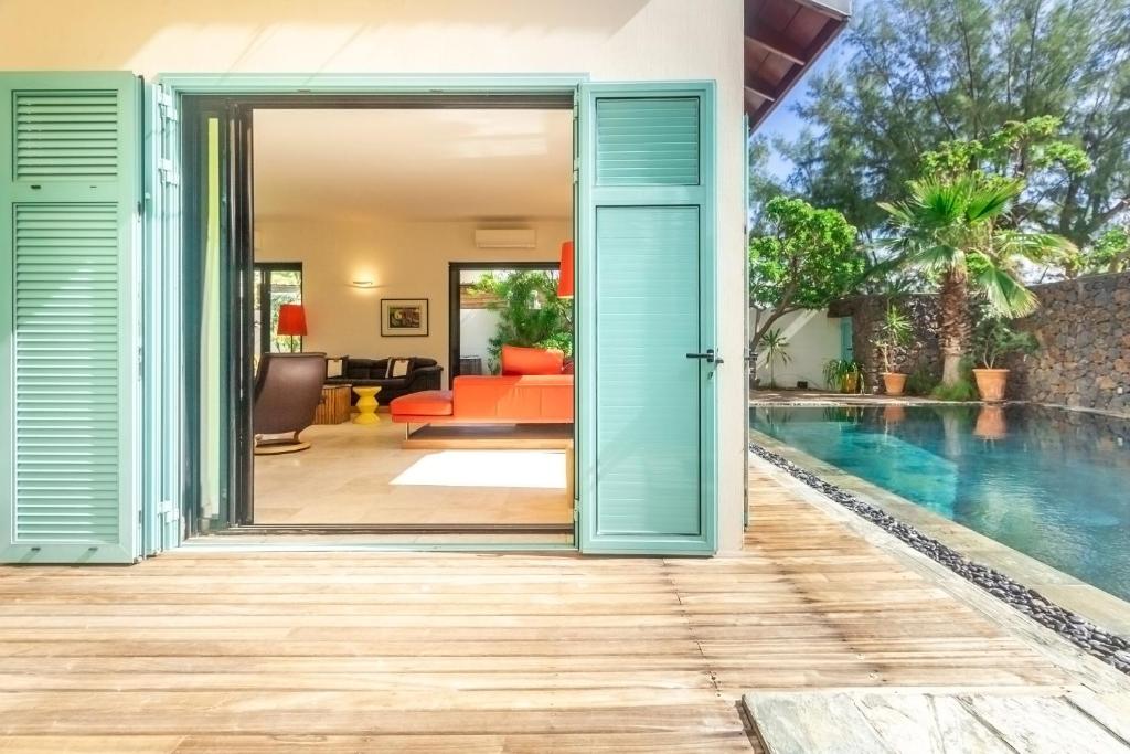 an open door of a house with a swimming pool at La Musarde, magnifique villa avec piscine chauffée à deux pas de la plage de Boucan Canot in Saint-Gilles-les-Bains