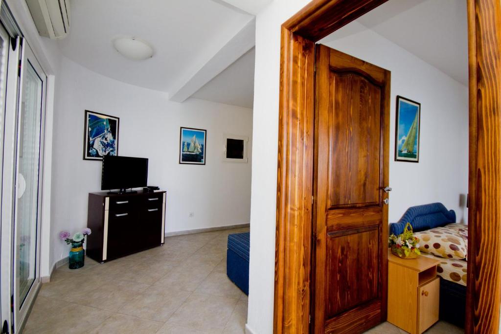 a room with a bed and a wooden door at Apartments Dora in Dobra Voda