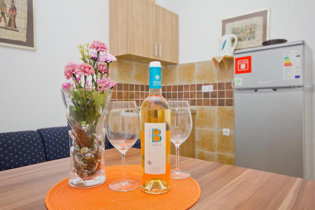 a bottle of wine and two glasses on a table at Apartments Dora in Dobra Voda