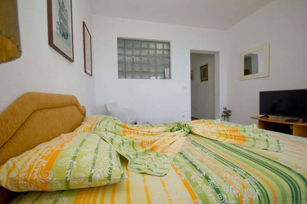 a bedroom with a bed with a colorful comforter at Apartments Dora in Dobra Voda
