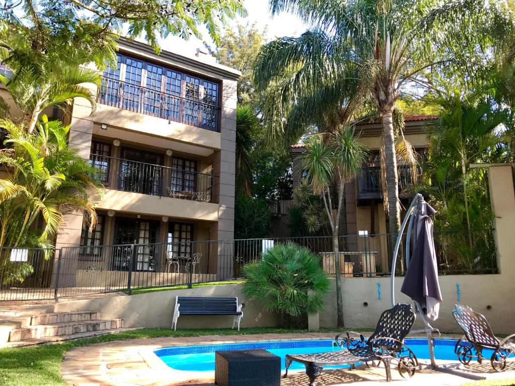 un complejo con piscina y un edificio en Waterfalls Boutique Hotel, en Pretoria