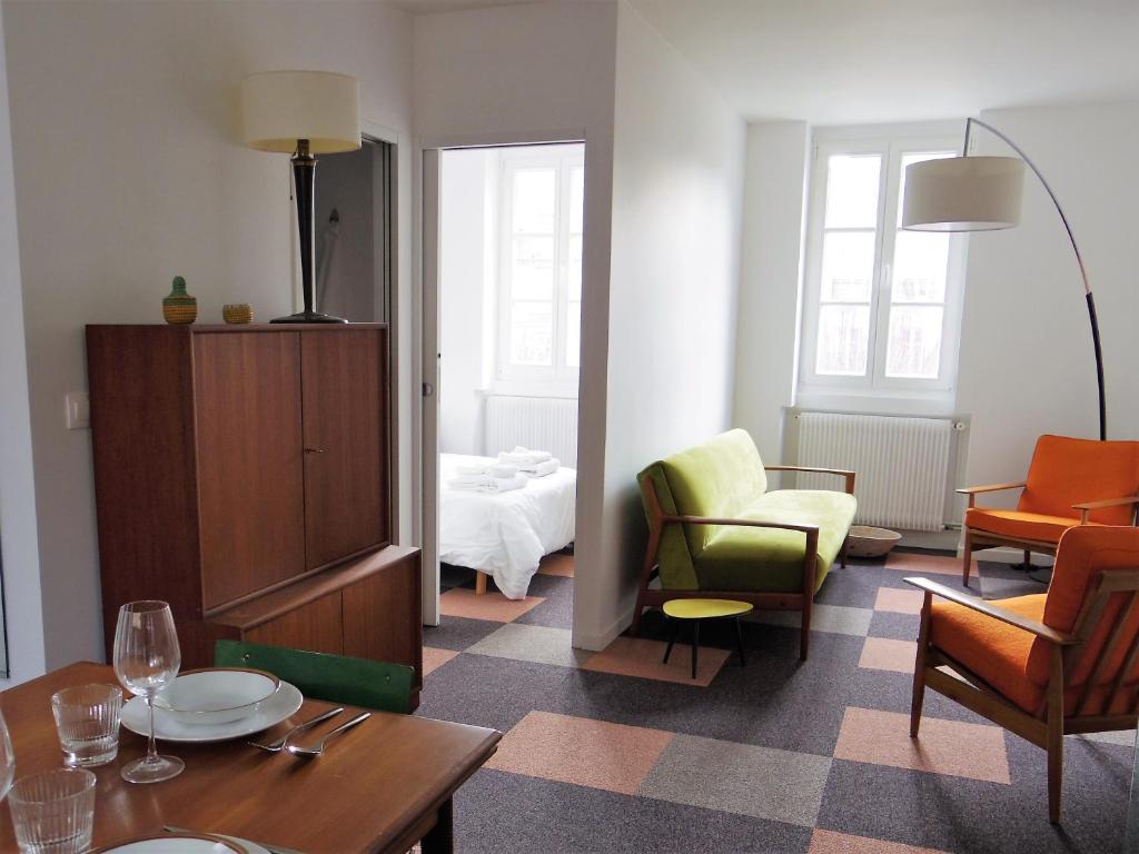 una sala de estar con una mesa y sillas en l'Otis et le Titouan Saint-Sauveur, en Dinan