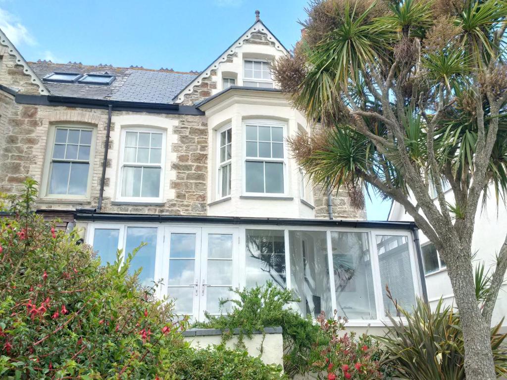 a house with large windows and a palm tree at Michaelstow in Perranporth