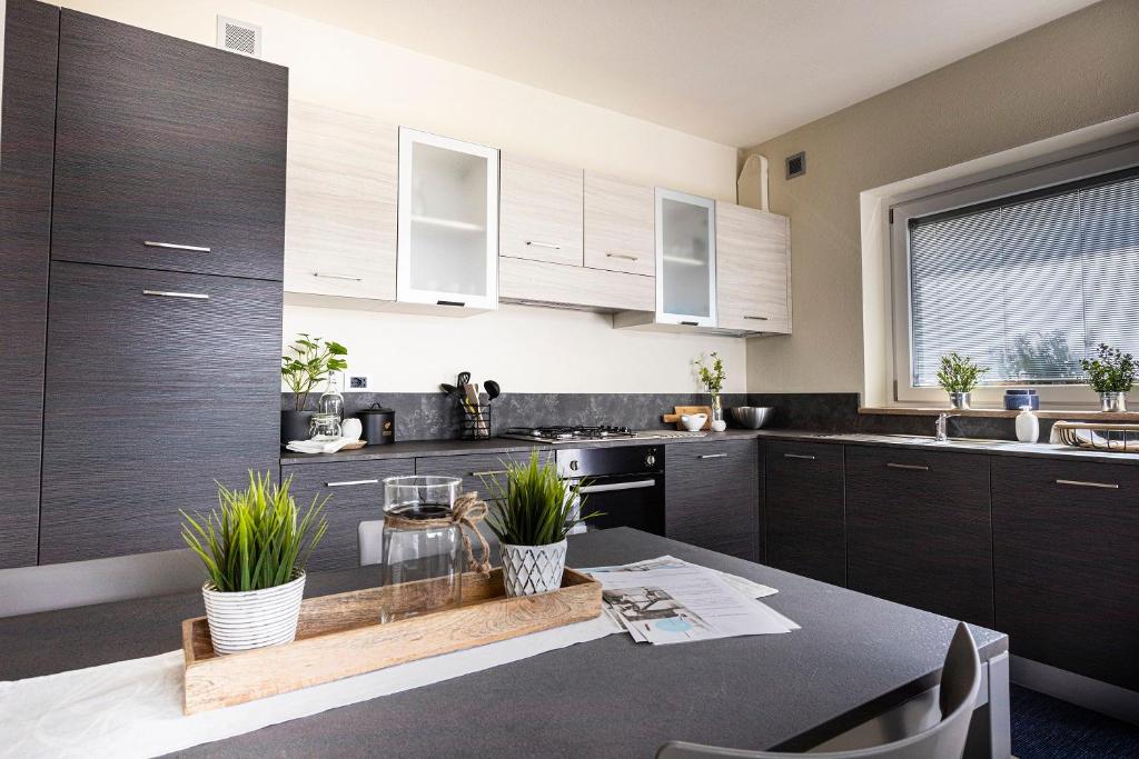 una cocina con armarios de madera y una mesa con plantas en L'Atelier du Temps - A&G Apartment en Aosta