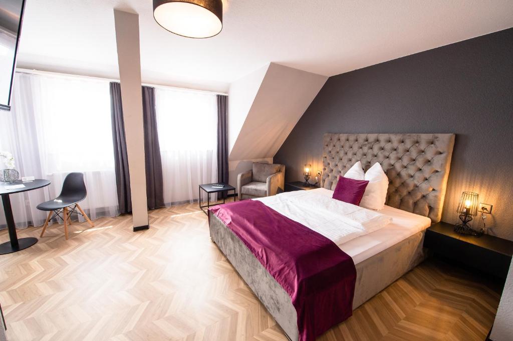 um quarto com uma cama grande, uma mesa e cadeiras em V Business Appartments Stuttgart Magstadt em Magstadt
