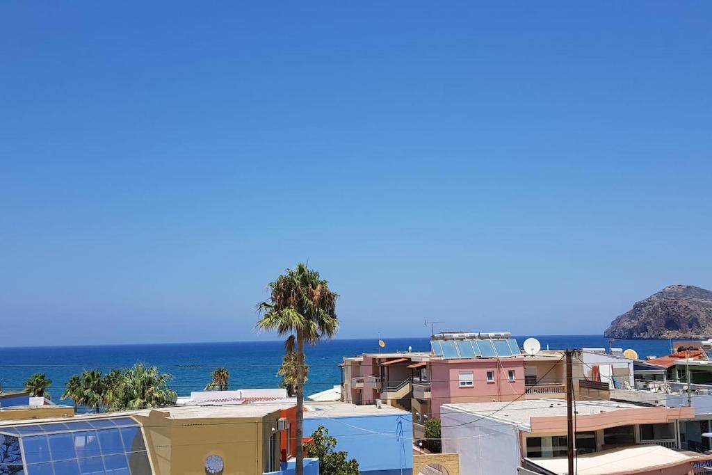 a city with houses and the ocean in the background at Double View Apartment in Agia Marina Nea Kydonias