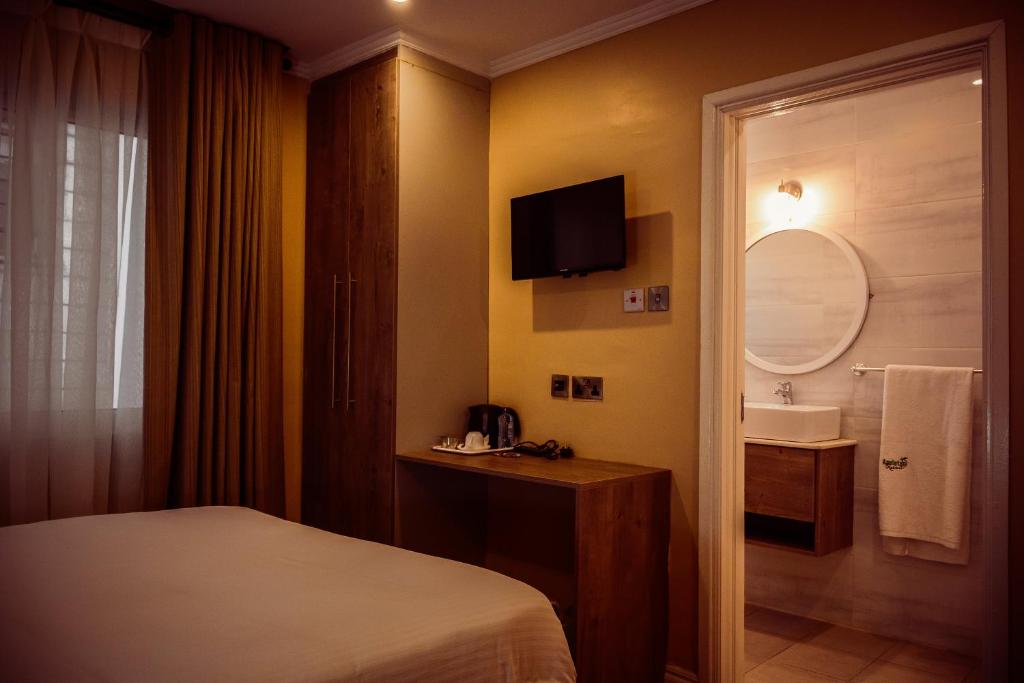 ナイロビにあるAppleton Resortのベッドとシンク付きのホテルルーム