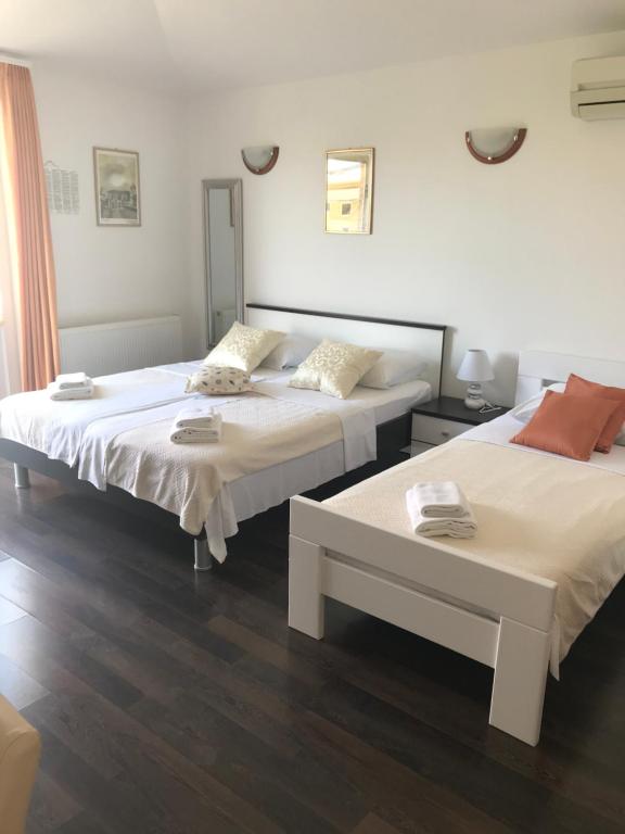 dos camas sentadas una al lado de la otra en una habitación en Apartment House Jerko, en Kaštela
