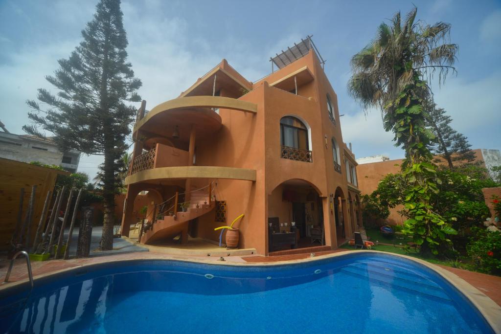 une maison avec une piscine en face de celle-ci dans l'établissement Nyéléni maison sahel, à Dakar
