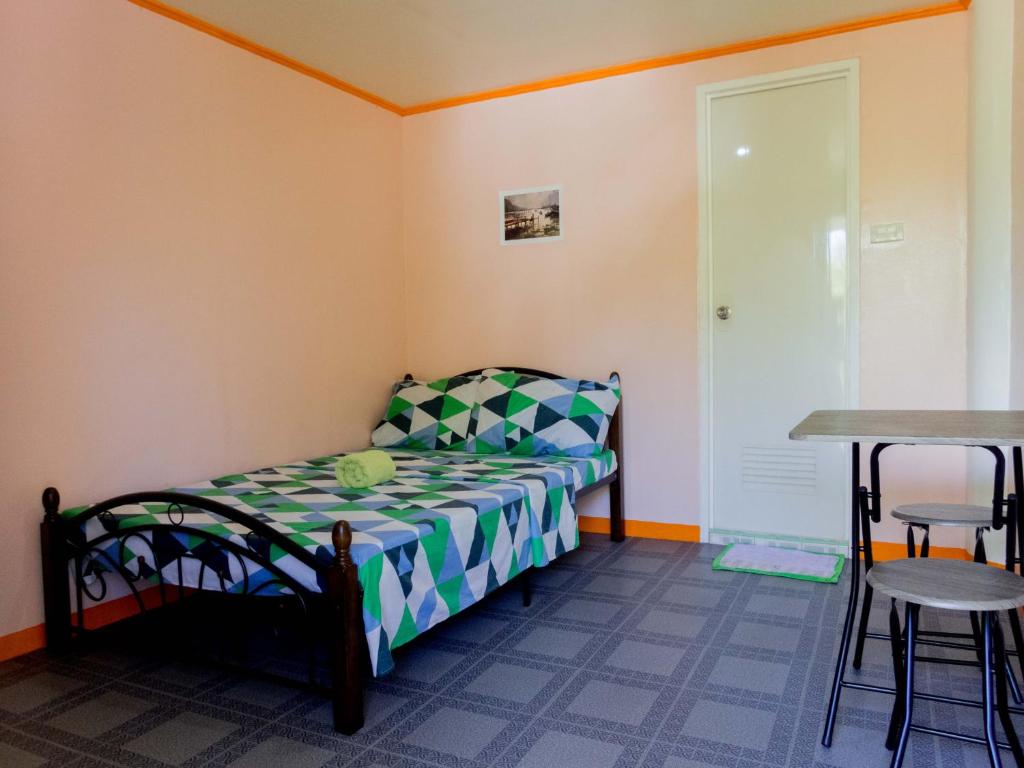 ein kleines Schlafzimmer mit einem Bett und einem Tisch in der Unterkunft J&J Tourist Inn in Panglao